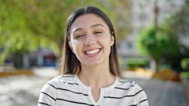 Genç, güzel İspanyol kadın gülümsüyor. Parkta kendine güveniyor.