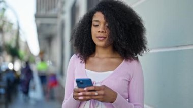 Afro-Amerikalı kadın akıllı telefon kullanıyor.