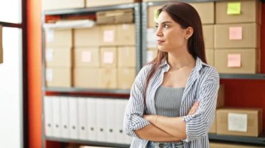 Genç, güzel, İspanyol bir kadın. İş adamı. Ofiste kollarını kavuşturup el kol hareketi yapıyor.