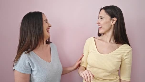 Dwie Kobiety Uśmiechające Się Pewnie Stojące Odosobnionym Różowym Tle — Wideo stockowe