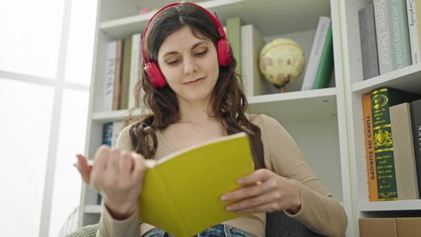 Muda Cantik Hispanik Perempuan Siswa Mendengarkan Buku Membaca Musik Perpustakaan — Stok Video