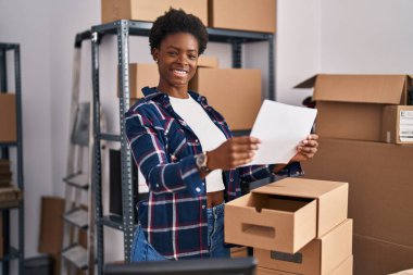 Afrika kökenli Amerikalı kadın ecommerce iş adamı ofiste belge okuyor.
