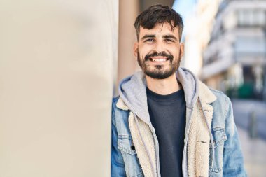 Sokakta kendinden emin gülümseyen İspanyol genç adam.