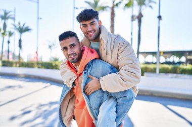 Sokakta birbirine sarılan iki erkek, erkek arkadaşını kucaklıyor.