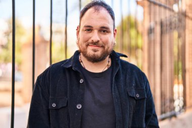 Sokakta kendinden emin gülümseyen İspanyol genç adam.
