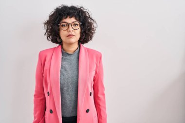 Tecrit edilmiş arka planda duran kıvırcık saçlı İspanyol kadın yüzünde ciddi bir ifadeyle rahatlamış. Basit ve doğal bir şekilde kameraya bakıyorsun.. 