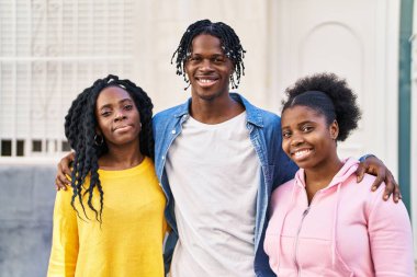 Afro-Amerikalı arkadaşlar gülümsüyor sokakta birbirlerine sarılıyorlar.