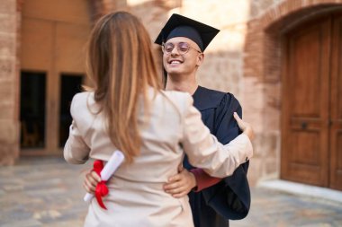 Man and woman mother and son hugging each other celebrating graduation at university