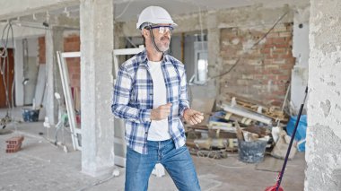 İnşaat alanında kendine güvenen orta yaşlı bir inşaatçı.