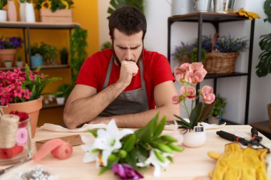 Çiçekçide çalışan İspanyol genç adam kendini kötü hissediyor ve soğuk algınlığı veya bronşitin belirtisi olarak öksürüyor. sağlık hizmeti kavramı. 