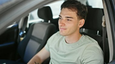 Young hispanic man smiling confident driving car at street