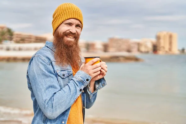 Young Redhead Man Smiling Confident Drinking Cup Coffee Seaside — Stockfoto
