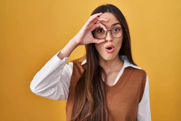 Sarı Arka Planda Duran Genç Esmer Kadın Gözlük Takıyor Şaşırmış — Stok fotoğraf