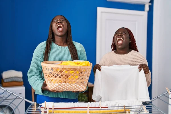 Dwie Afrykańskie Kobiety Wiszące Sznurze Ubrań Wściekłe Wściekłe Krzyczące Sfrustrowane — Zdjęcie stockowe