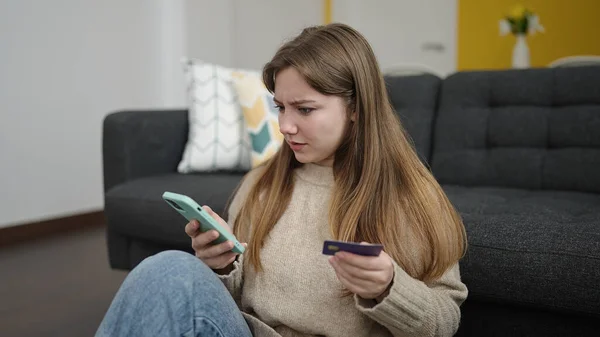 Młoda Blondynka Pomocą Smartfona Karty Kredytowej Siedzi Podłodze Domu — Zdjęcie stockowe