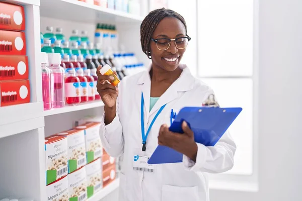Afrikaans Amerikaanse Vrouw Apotheker Holding Pillen Fles Lezen Document Bij — Stockfoto