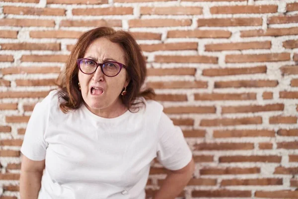 Mujer Mayor Con Gafas Pie Sobre Pared Ladrillos Cara Choque —  Fotos de Stock