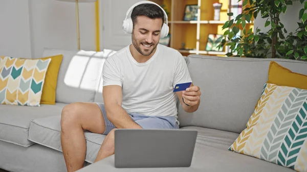 Młody Hiszpan Robi Zakupy Laptopem Kartą Kredytową Siedząc Kanapie Domu — Zdjęcie stockowe