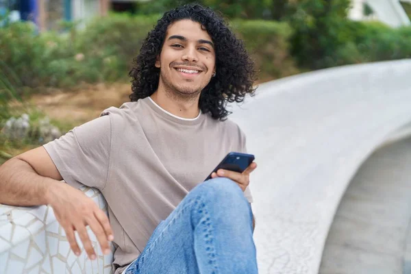 Hombre Latino Joven Usando Teléfono Inteligente Sentado Banco Parque — Foto de Stock