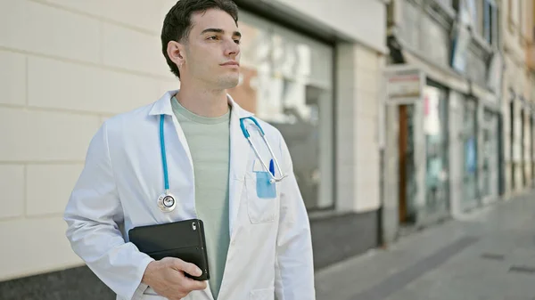 Młody Latynoski Lekarz Stojący Poważnym Wyrazem Twarzy Trzymający Touchpad Szpitalu — Zdjęcie stockowe