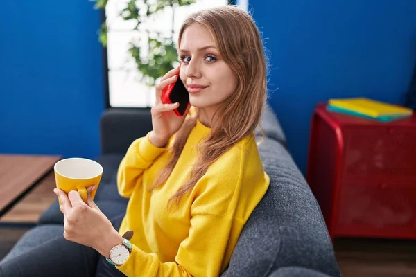 Young Blonde Woman Talking Smartphone Drinking Coffee Home — Stockfoto