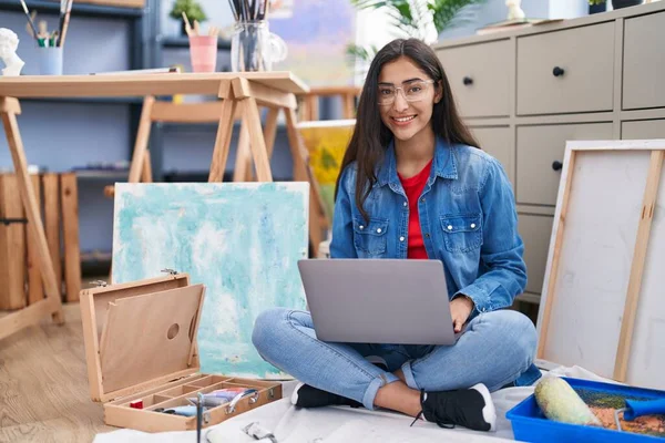 年轻的少女坐在艺术工作室里 用笔记本电脑 面带微笑 面带微笑 面带微笑 看上去很积极 很快乐 — 图库照片