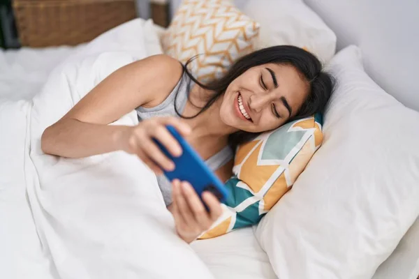 Νεαρή Ισπανόφωνη Κοπέλα Που Χρησιμοποιεί Smartphone Ξαπλωμένη Στο Κρεβάτι Στο — Φωτογραφία Αρχείου