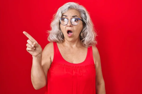 Middle Age Woman Grey Hair Standing Red Background Surprised Pointing — Stock Photo, Image
