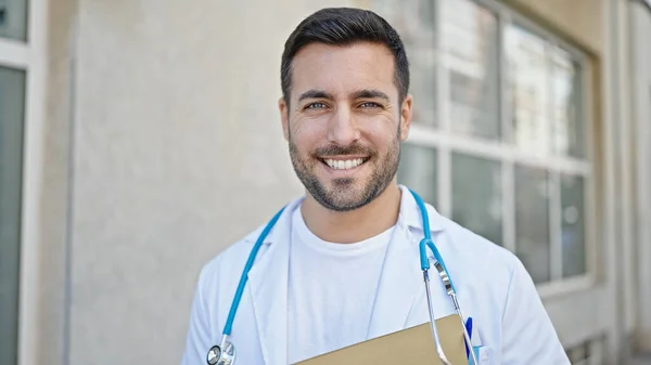 Junger Hispanischer Arzt Lächelt Zuversichtlich Und Hält Medizinischen Bericht Krankenhaus — Stockfoto