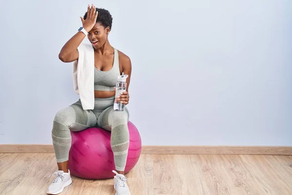 Afroamerikansk Kvinna Sportkläder Sitter Pilates Boll Förvånad Med Hand Huvudet — Stockfoto