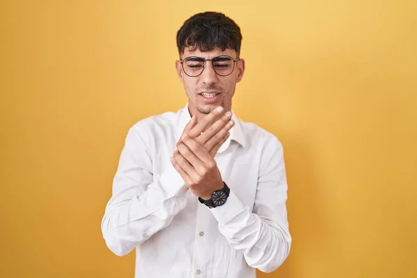 Homem Hispânico Jovem Sobre Fundo Amarelo Sofrendo Dor Nas Mãos — Fotografia de Stock