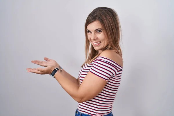 Молода Іспаномовна Жінка Стоїть Над Ізольованим Тлом Вказуючи Сторону Руки — стокове фото