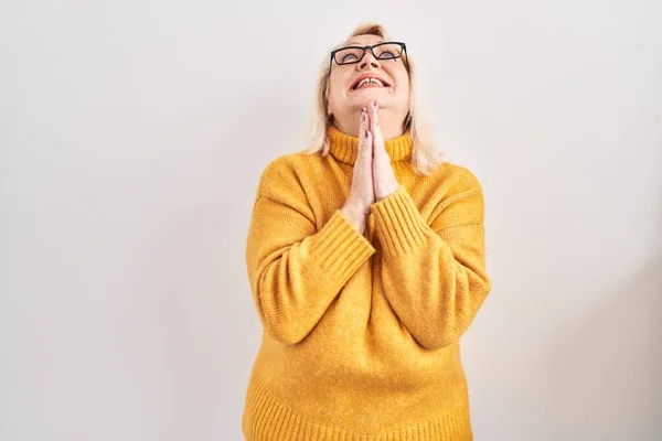 中年の白人女性は眼鏡をかけ 身辺の物乞いや祈りの上に立ち 希望の表情で非常に感情的かつ心配しています お願い — ストック写真