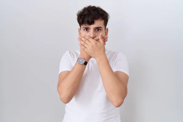 カジュアルな白いTシャツを着た若いバイナリの男は間違いのために手で口を覆うショックを受けた 秘密の概念 — ストック写真