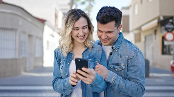 남자와 여자가 길거리에서 스마트폰을 사용하는 — 스톡 사진