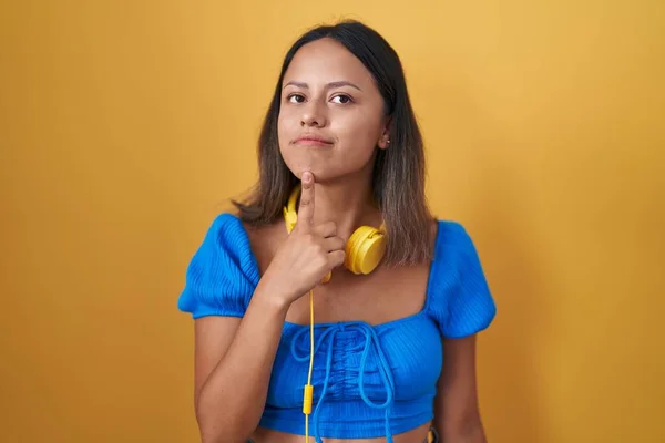 Латиноамериканка Стоящая Жёлтом Фоне Думающая Сомнениях Пальцем Подбородке Глядя Вверх — стоковое фото