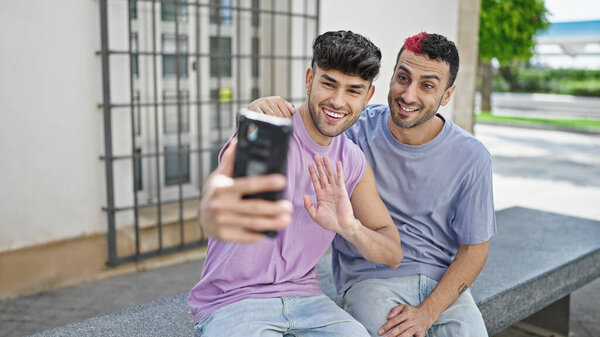 Two men couple smiling confident having video call at street