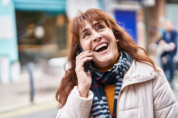 中年の女性は自信を持って話して笑顔路上でスマートフォン — ストック写真