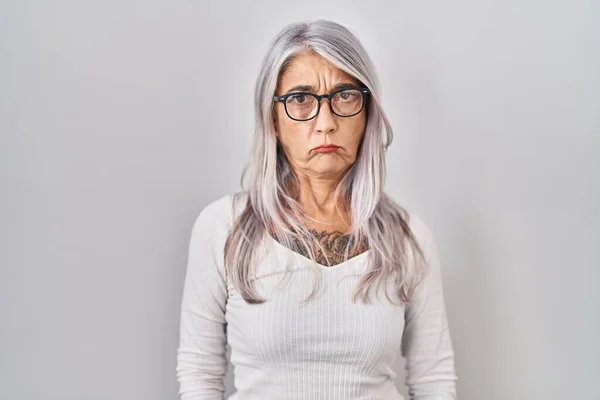白髪の中年女性は 問題のために動揺を眉をひそめて 白い背景懐疑的かつ神経の上に立っている 否定的な人 — ストック写真
