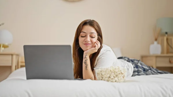 Молода Красива Іспаномовна Жінка Використовуючи Ноутбук Їсть Попкорн Лежить Ліжку — стокове фото