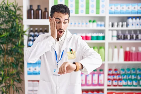 Hombre Hispano Guapo Trabajando Farmacia Mirando Reloj Preocupado Temeroso Llegar —  Fotos de Stock