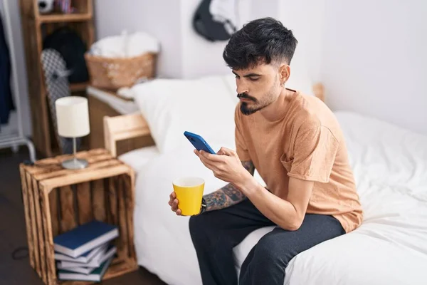 Νεαρός Ισπανός Που Χρησιμοποιεί Smartphone Πίνοντας Καφέ Στο Υπνοδωμάτιο — Φωτογραφία Αρχείου