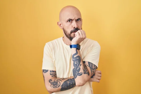 Hispánec Tetováním Stojící Nad Žlutým Pozadím Vypadá Vystresovaně Nervózně Rukama — Stock fotografie