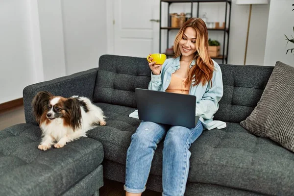 Junge Kaukasierin Trinkt Mit Laptop Kaffee Und Sitzt Mit Hund — Stockfoto