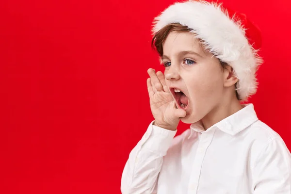 Malý Kavkazský Chlapec Vánočním Kloboukem Červeném Pozadí Bezradný Zmatený Otevřenou — Stock fotografie