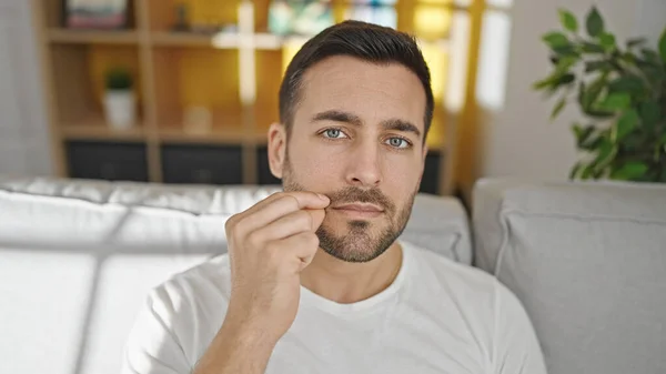 Young Hispanic Man Sitting Sofa Doing Closing Mouth Gesture Home — Stock Photo, Image