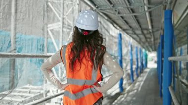 Güzel İspanyol kadın mimar gülümsüyor. Kollarını kavuşturup caddede duruyor.