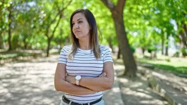 Ortadoğulu bir kadın parkta kol kola girmiş saate bakıyor.