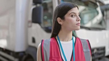 Genç, güzel İspanyol kadın kurye sokakta kendine güvenerek gülümsüyor.