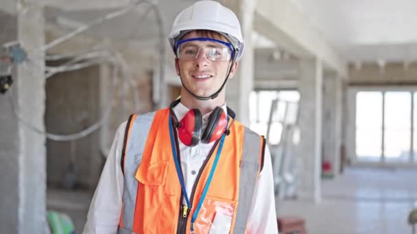 年轻的高加索人建筑师微笑着自信地站在建筑工地 — 图库视频影像